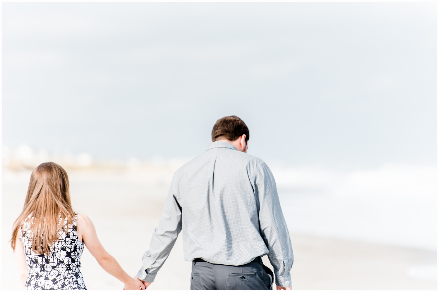 engaged couple holding hands on beach