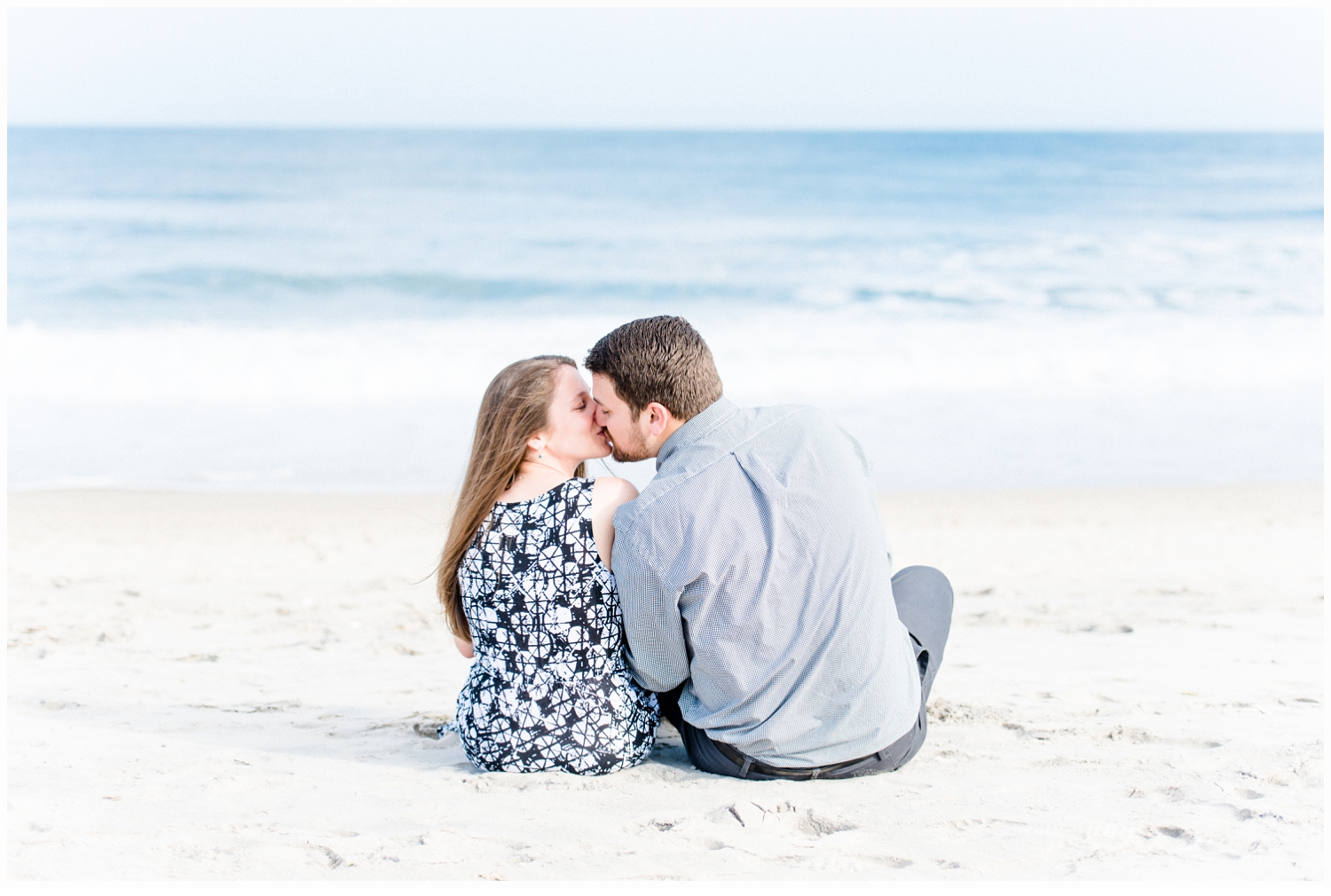 engaged couple kissing on the beach