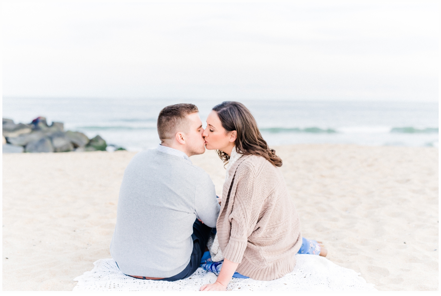 engaged couple on beach kissing