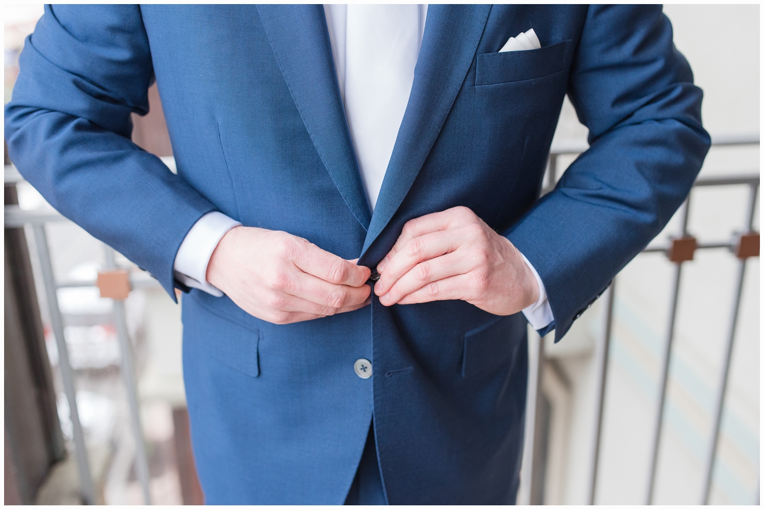 groom buttoning his suit