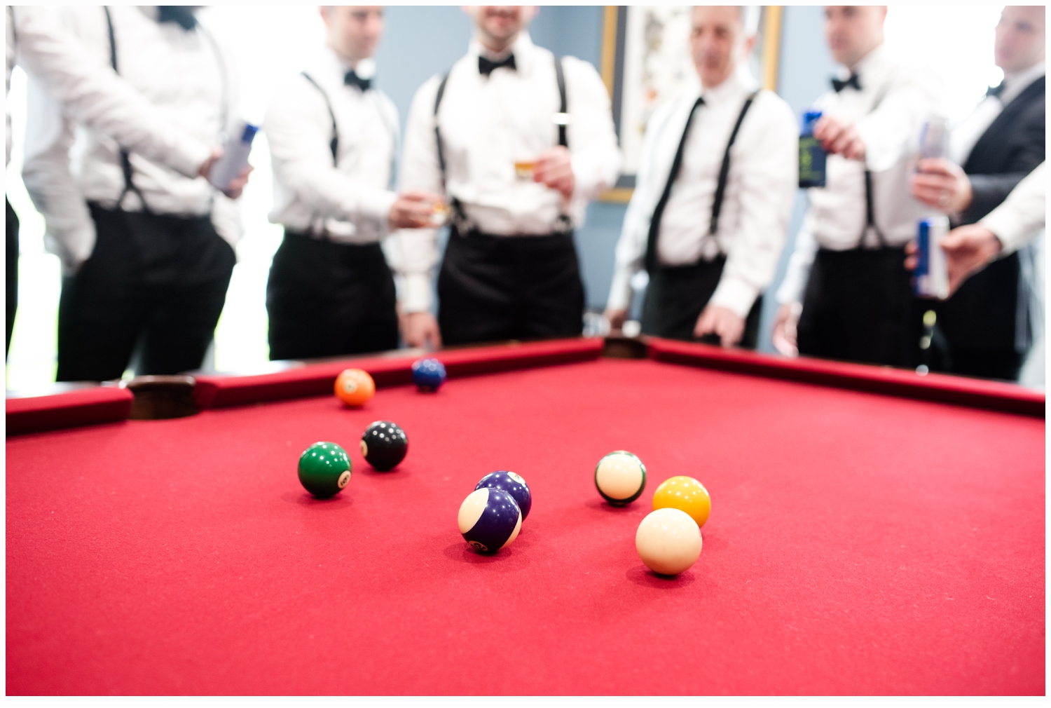 groom and groomsmen playing pool