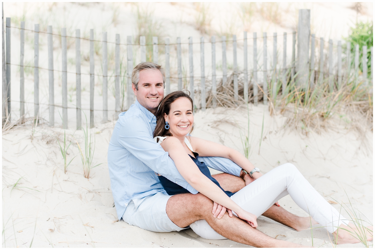 couple sitting on beach dunes