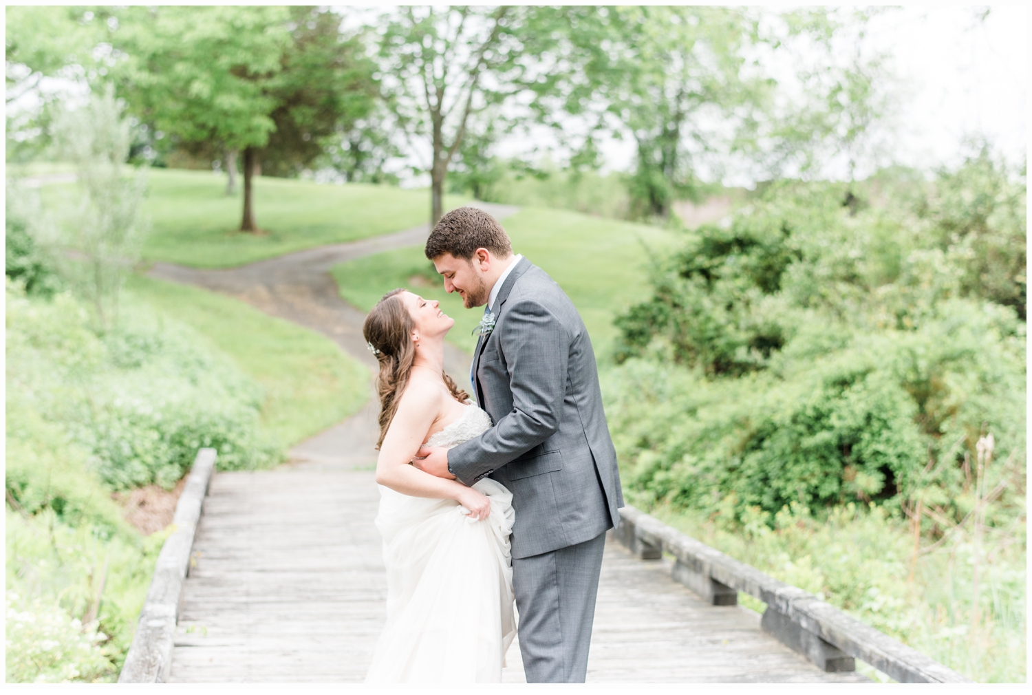 bride and groom kissing on bridge
