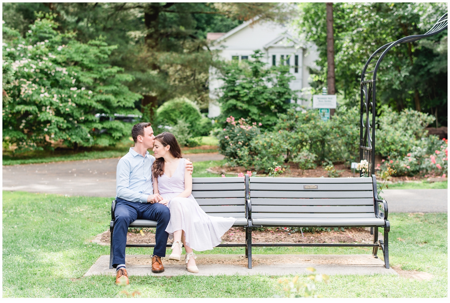 couple engaged sitting on a park bench
