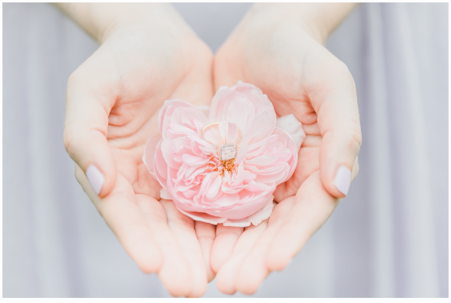 woman holding engagement ring in a rose