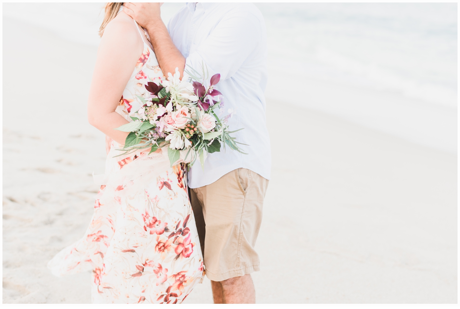 couple on a beach with a floral bouquet