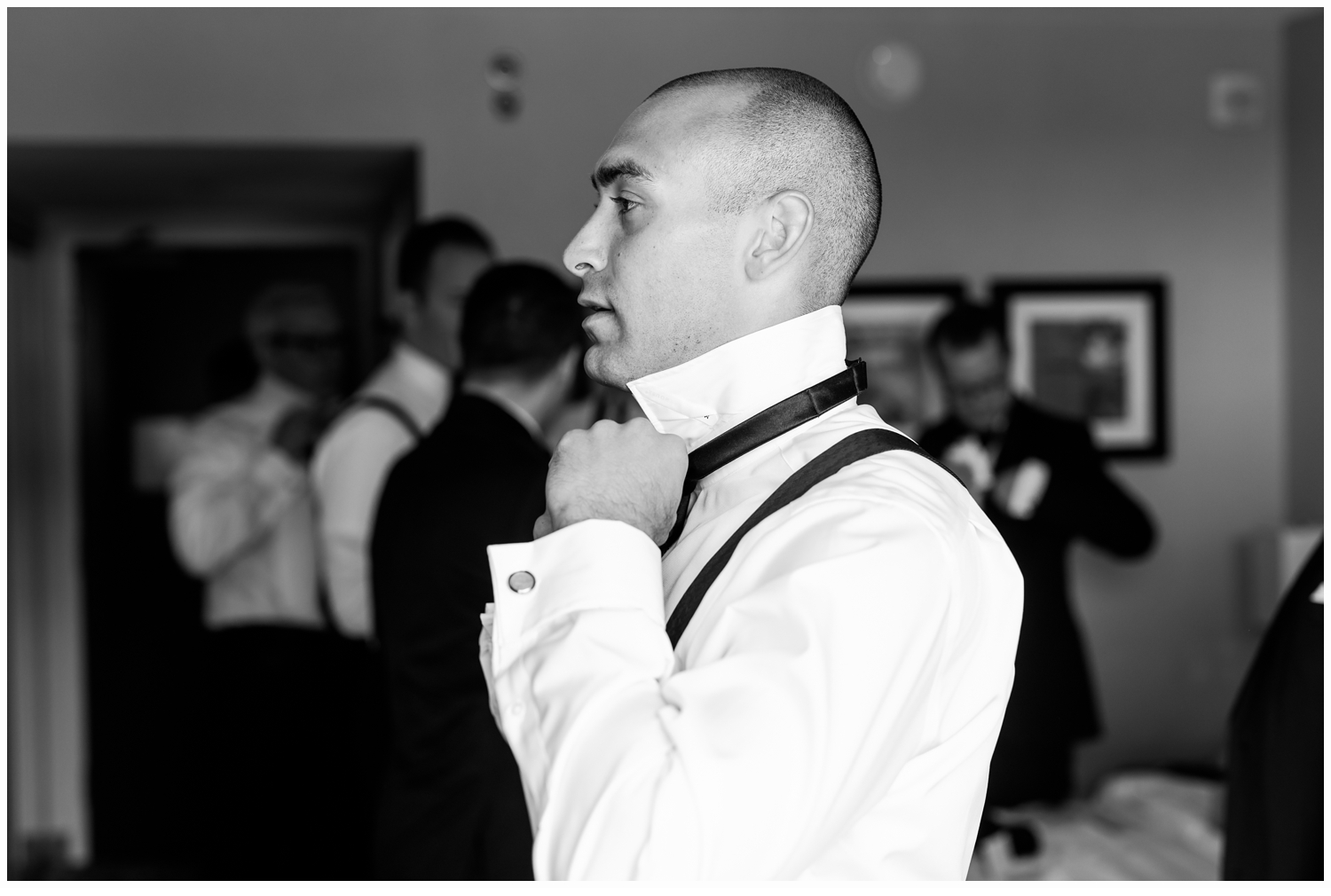 groom putting on his bow tie
