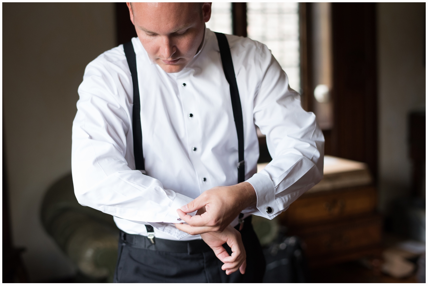 groom putting on cufflinks on wedding day