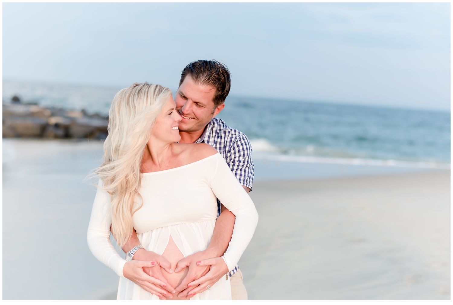 husband and wife hugging on beach