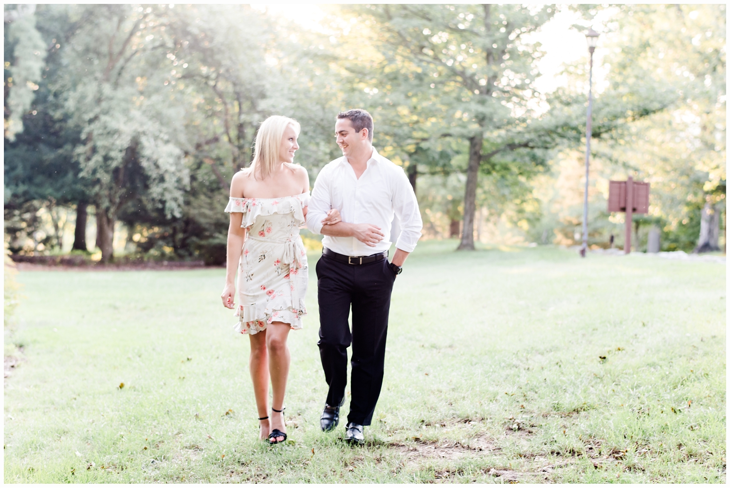 engaged couple walking in park