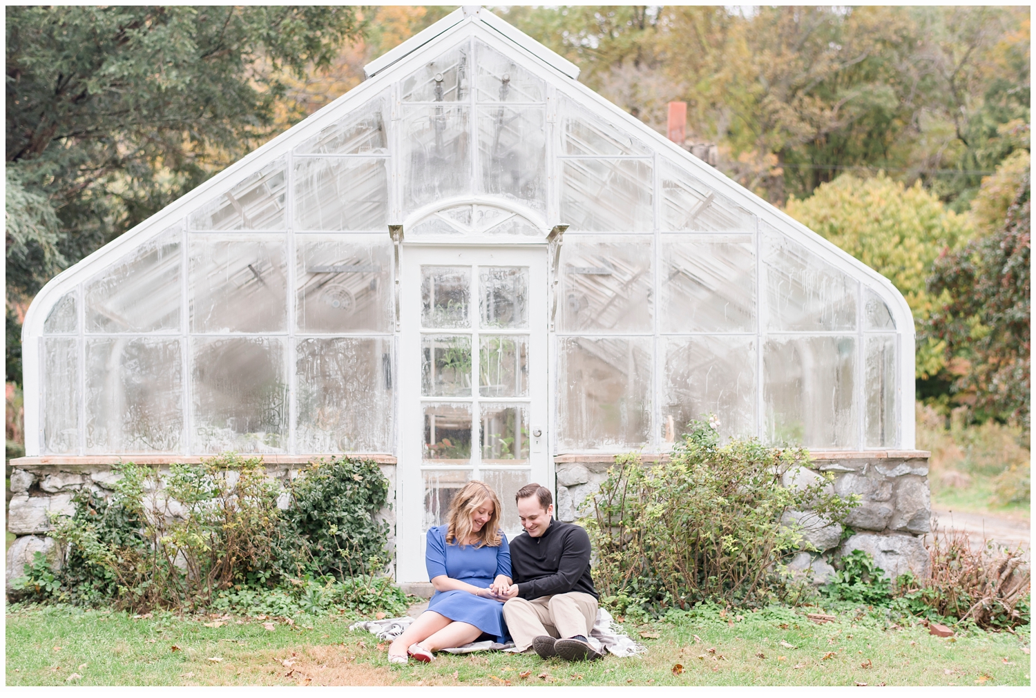 a couple sitting in front of a pretty green house