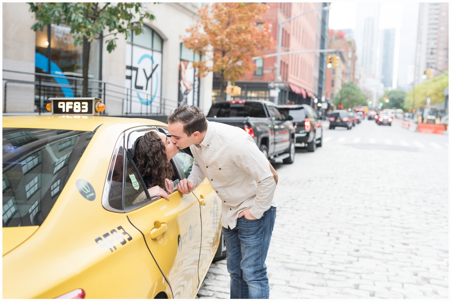 engaged couple kissing in yellow cab in nyc