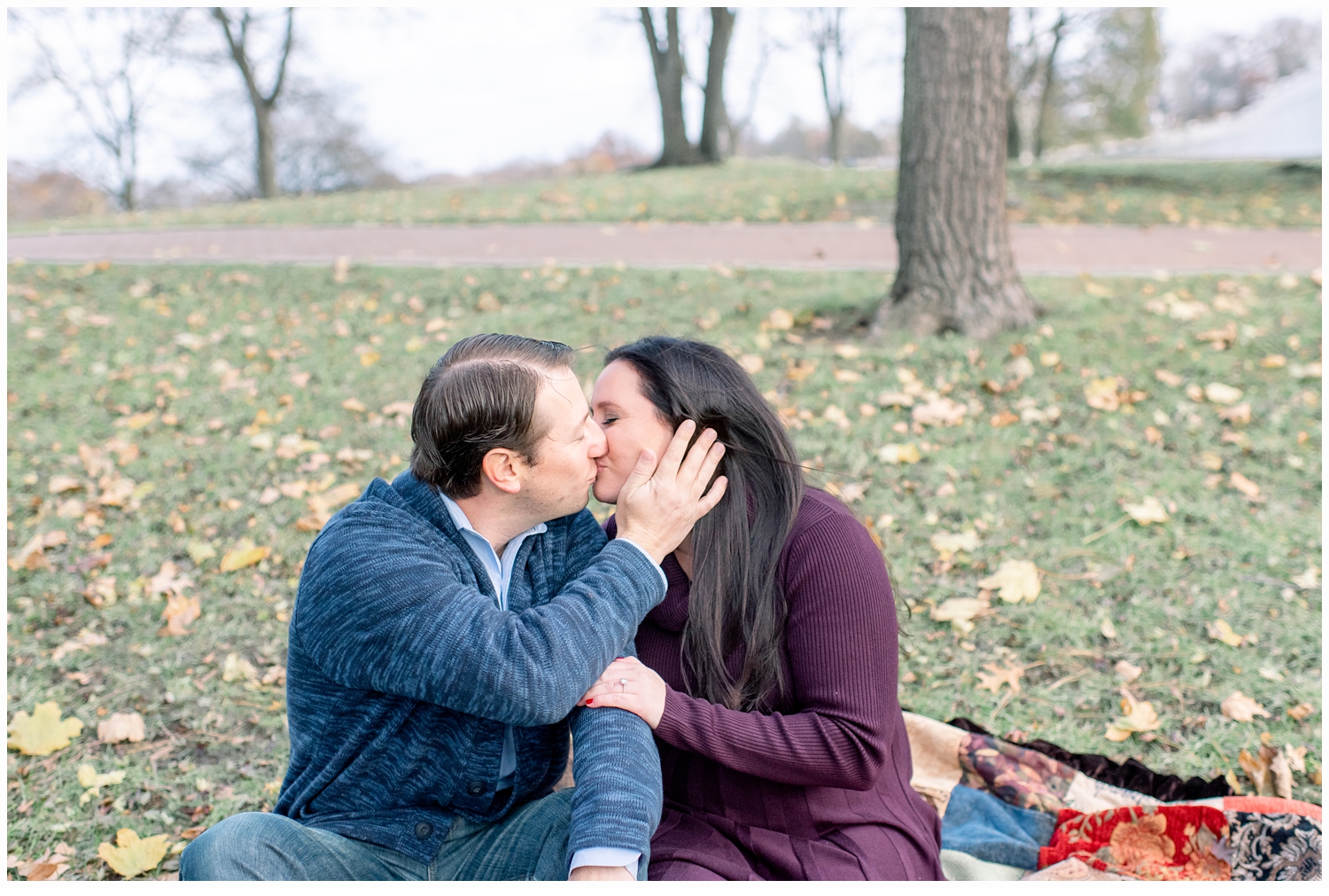 engaged couple kissing on lawn 