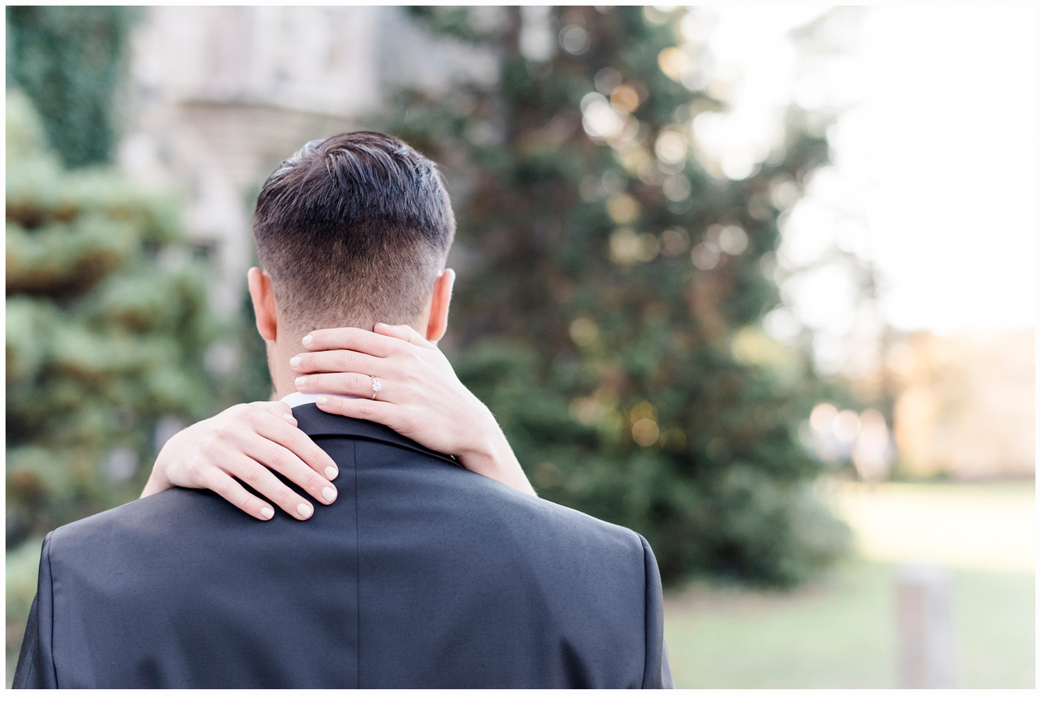 picture of woman holding man around his neck showing engagement ring