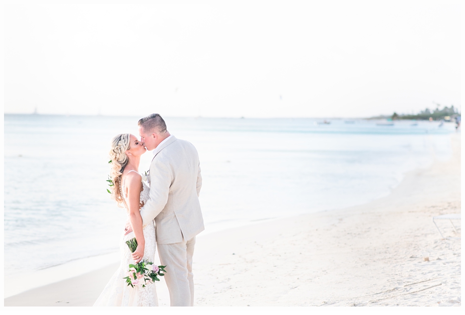 romantic kiss between bride and groom on the beach in aruba