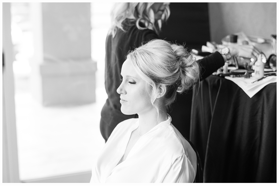 bride getting hair and makeup done on wedding day