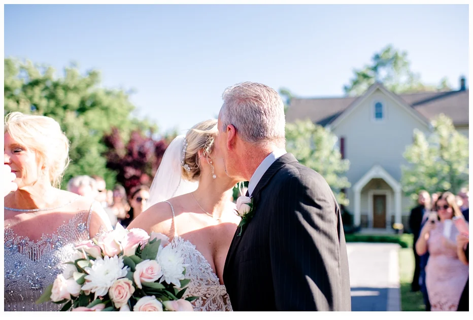 father giving bride away to groom at the altar