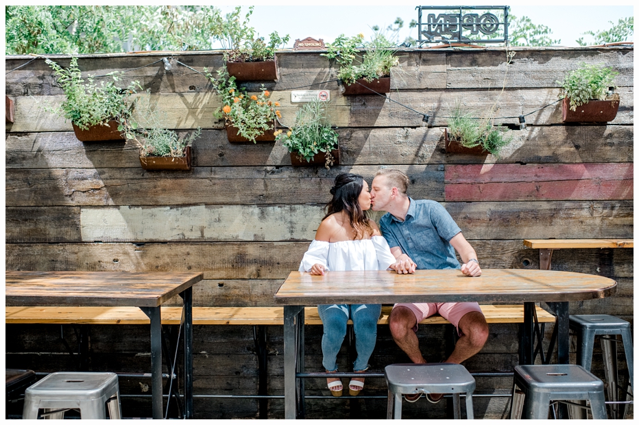 engaged couple kissing at a restaurant