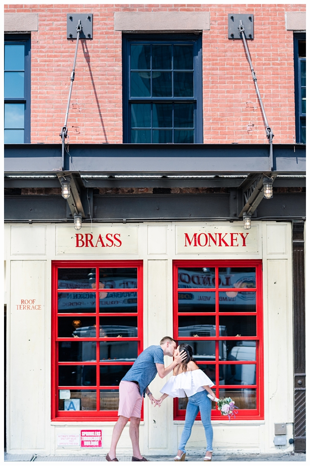 engaged couple in front of the brass monkey holding hands
