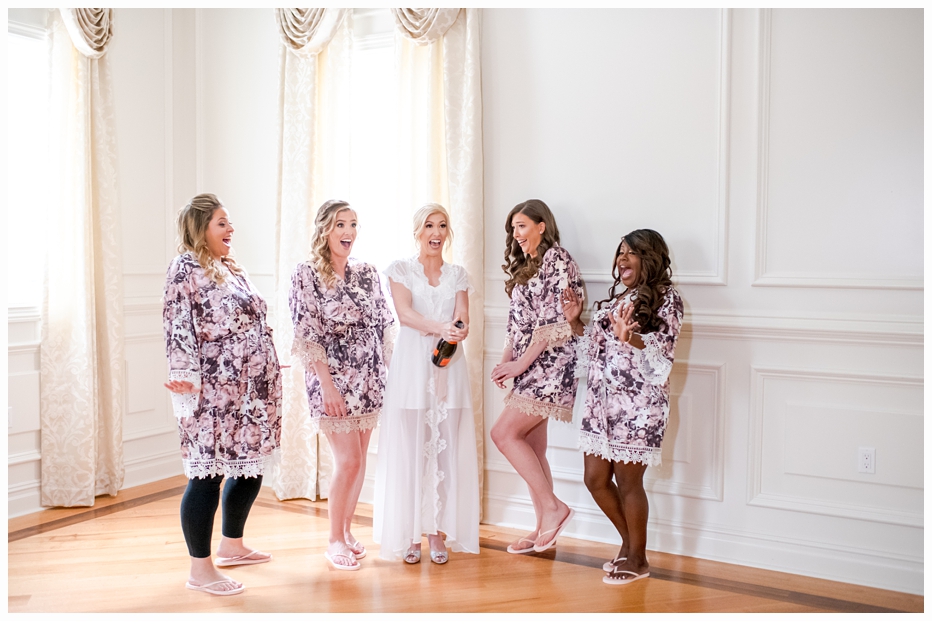 bride and bridesmaids in floral robes having a champagne toast