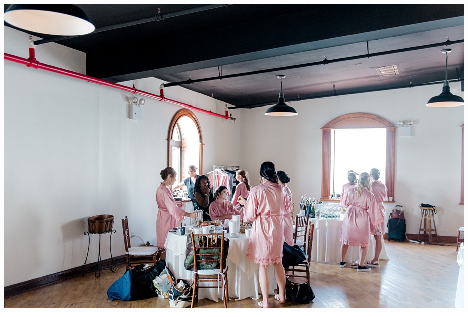 bride and bridesmaids in bridal suite wearing pink silk robes