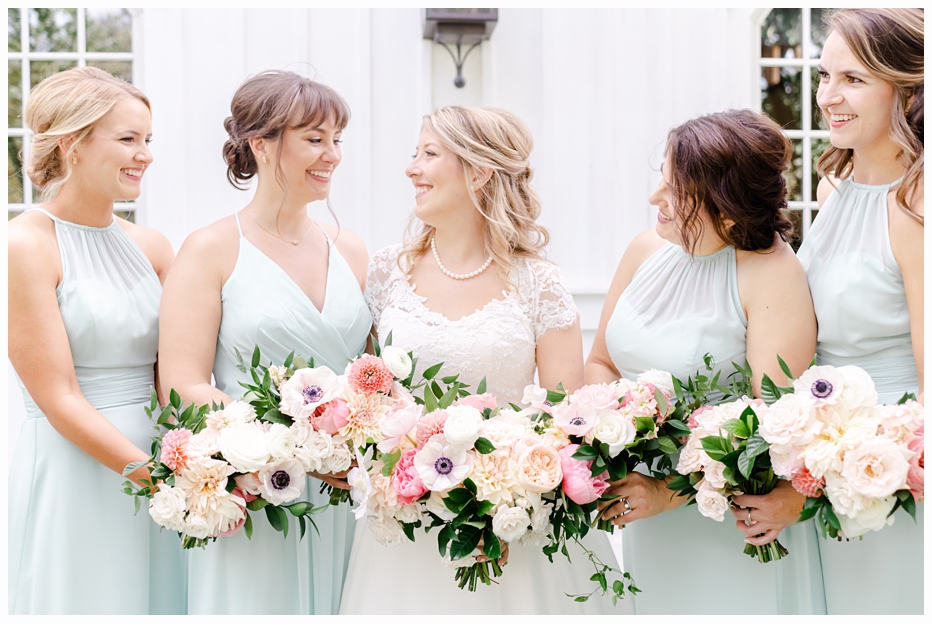 bride and bridesmaids laughing holding bouquets