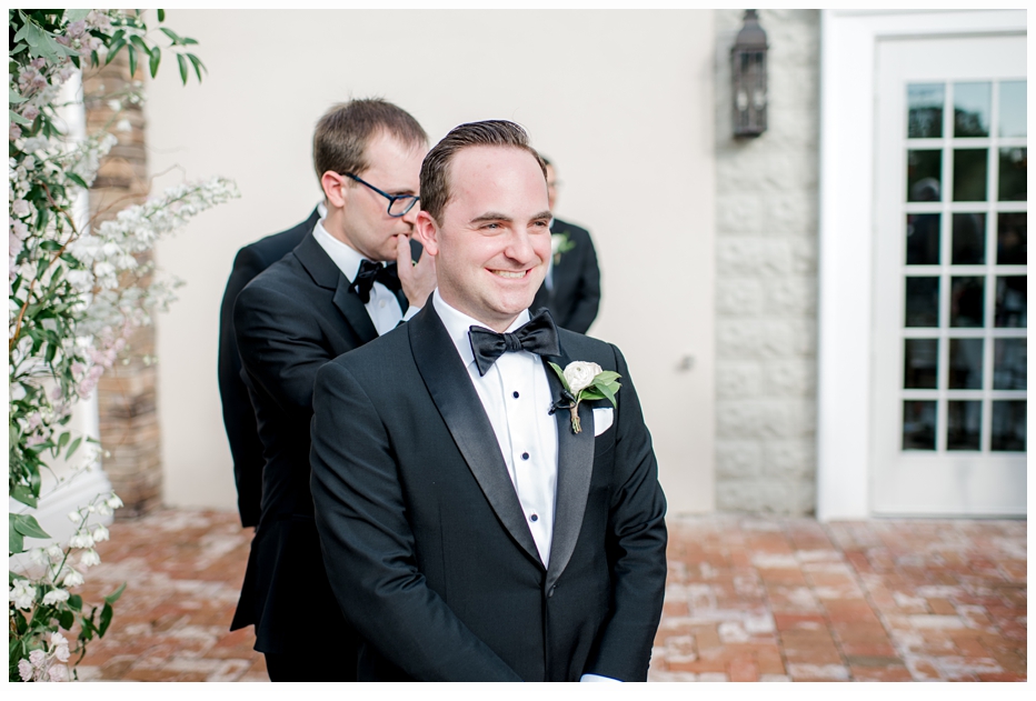 groom smiling as he sees his bride