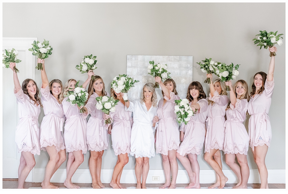bride and bridesmaids cheering with their bouquets
