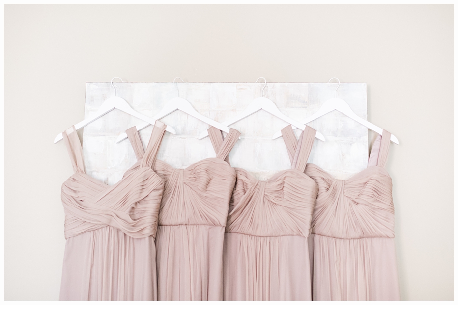 bridesmaids taupe colored dresses hanging up on a picture