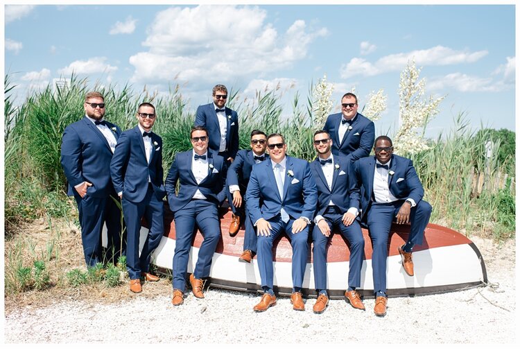 groom and groomsmen sitting on a boat