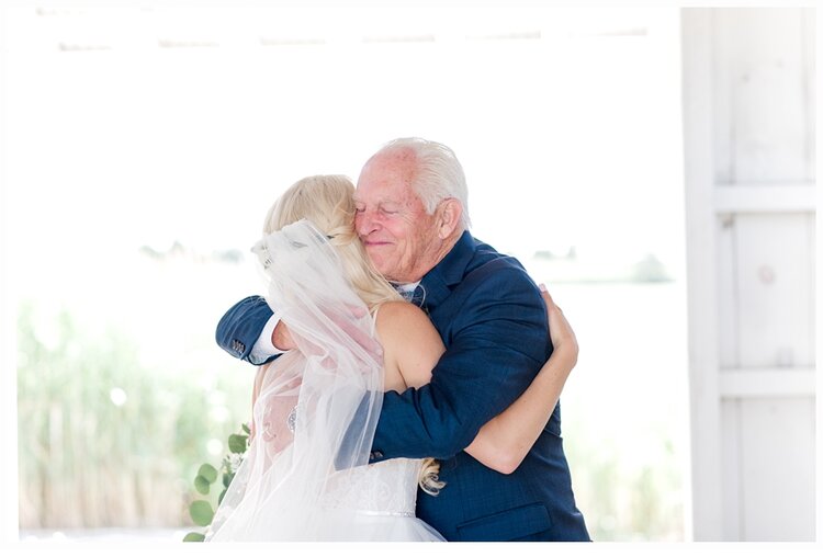 bride and dad hugging on wedding day