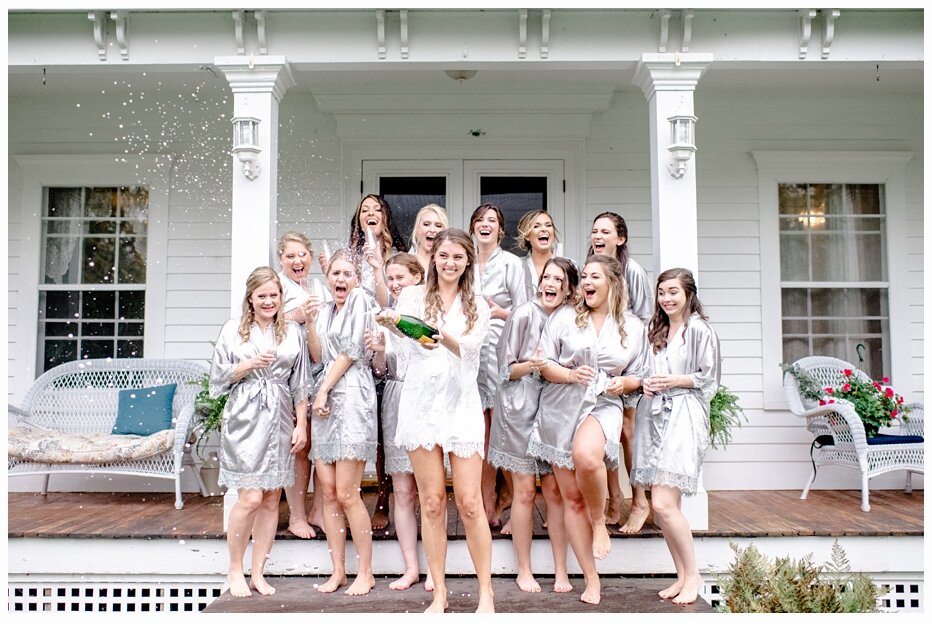 bride and bridesmaids popping champagne in their pajamas