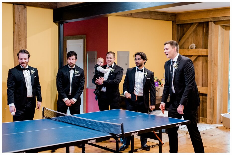 groom and groomsmen playing ping pong