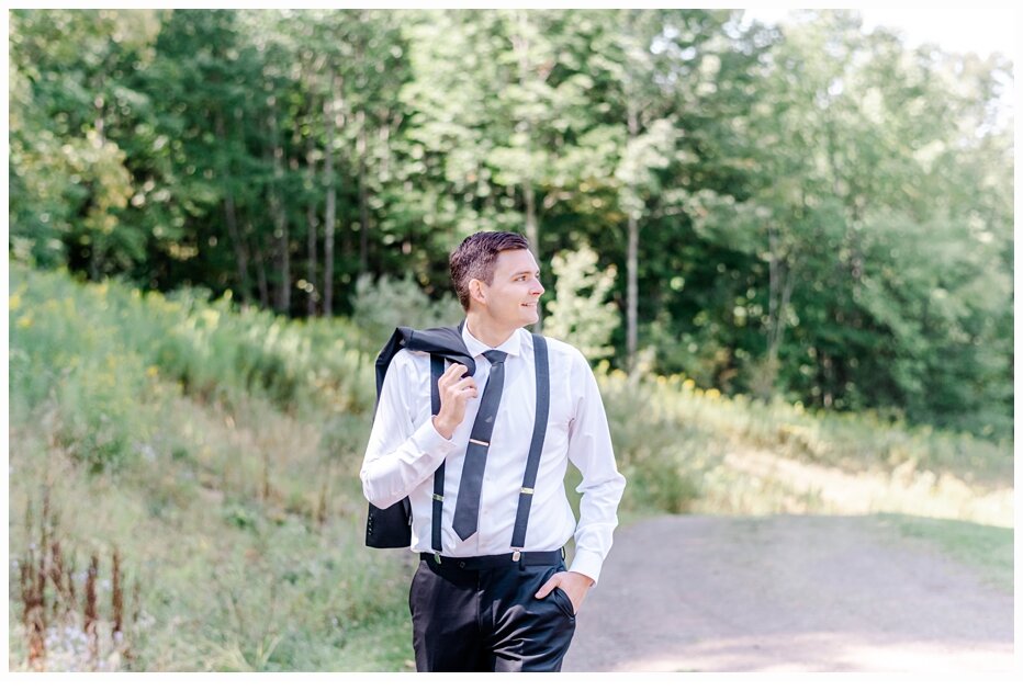 groom carrying his suit jacket over his shoulder
