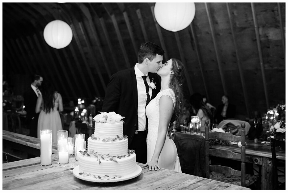 bride and groom cutting wedding cake and kissling