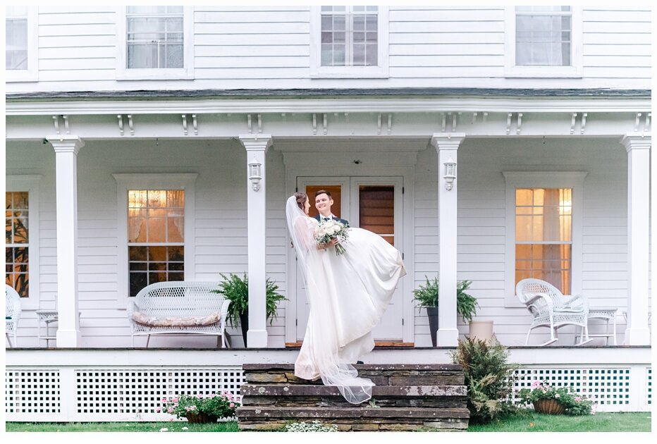 groom carrying bride over the threshold