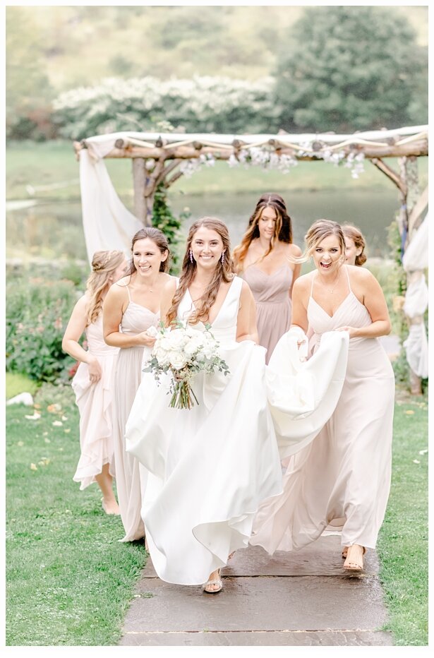 bridesmaids carrying the train of a brides gown