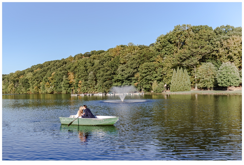 bride and groom in a row boat on a lake