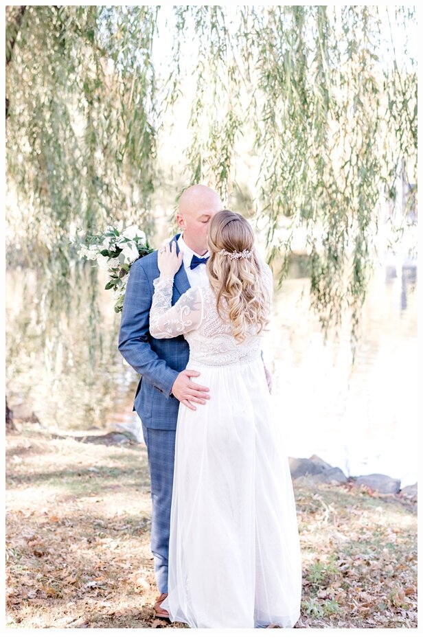 bride and groom kissing under willow tree