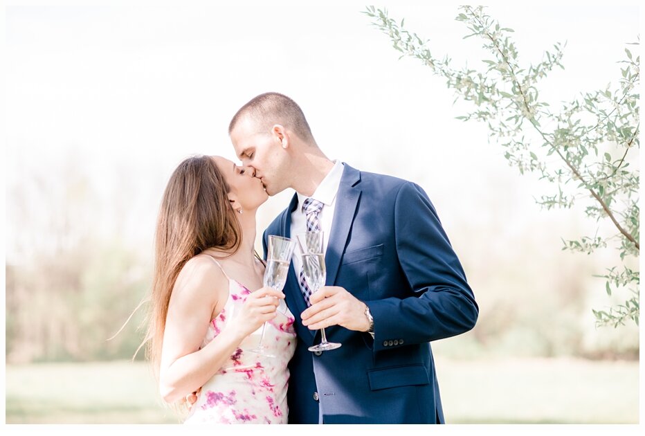 engaged couple kissing and toasting with champagne glasses