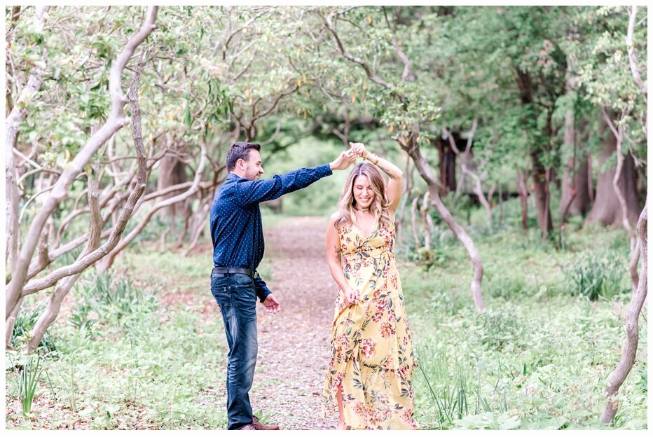 engaged couple dancing in a pretty field