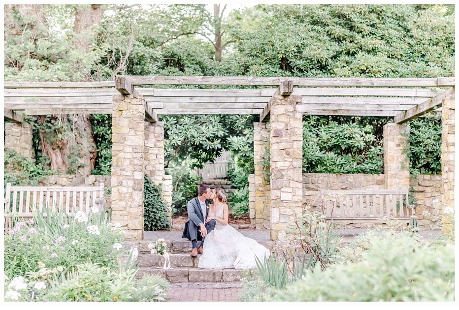 bride and groom sitting in a garden on wedding day