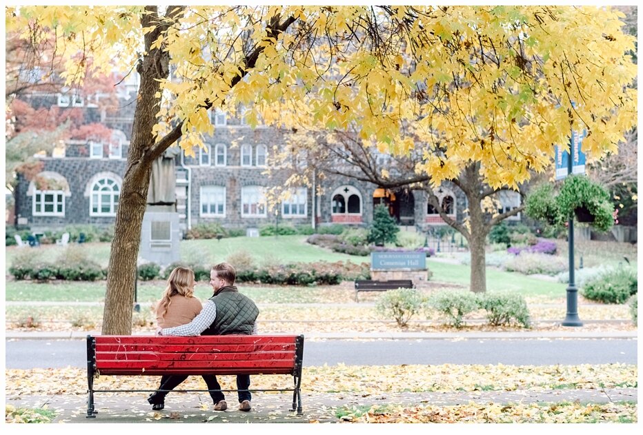engaged couple on a red park bench at moravian college