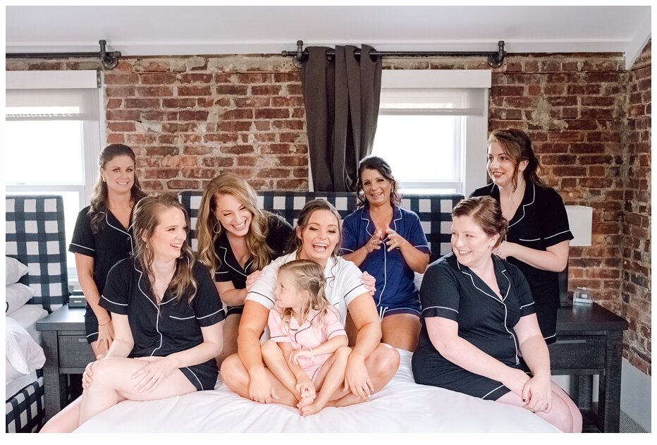 bride and bridesmaids in cute pajamas sitting on bed