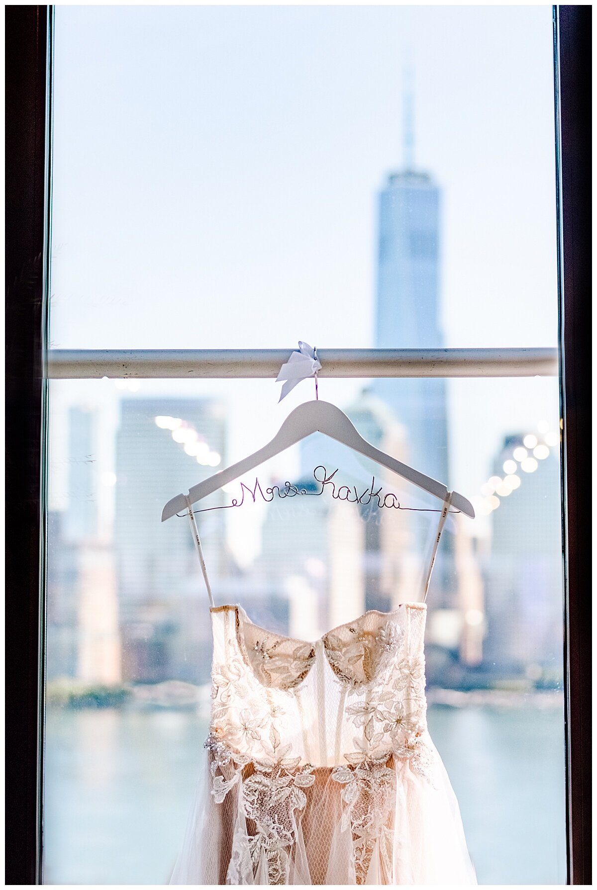 wedding gown in a window with NYC skyline in the background