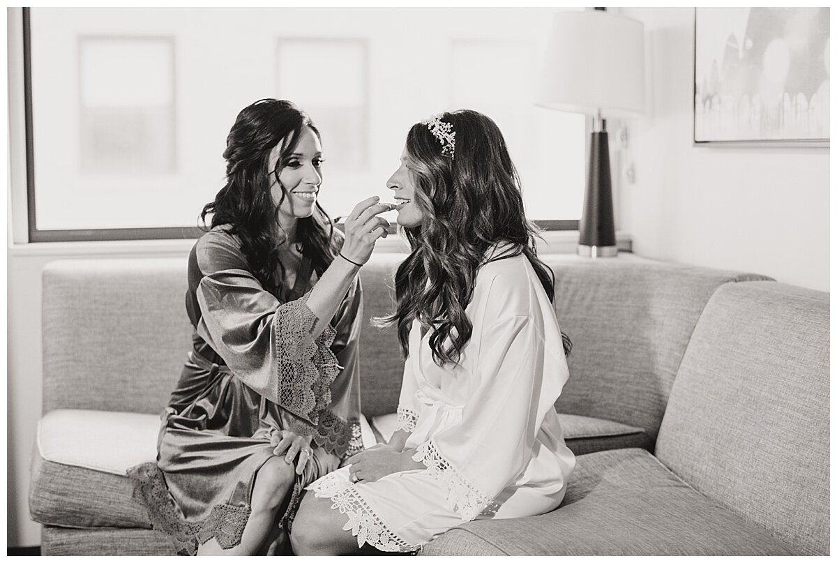 maid of honor putting lipstick on bride