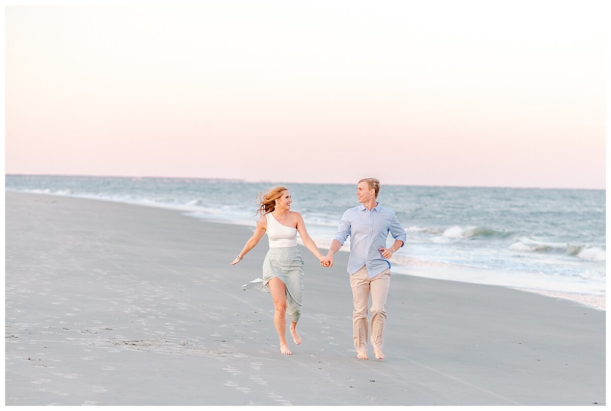 couple running on the beach for engagement session