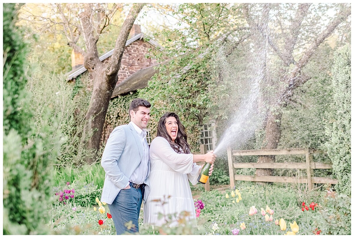 engaged couple popping a bottle of champagne