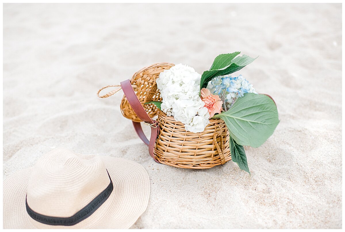 basket of flowers and a hat on the beach