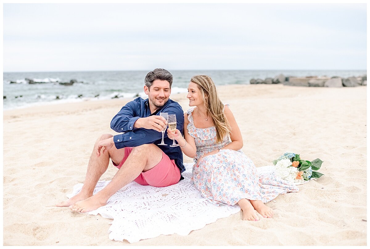 engaged couple having a champagne toast on the beach